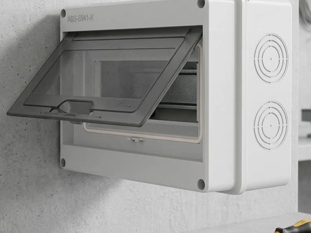 Wall-mounted distribution enclosure with hinged smoked cover